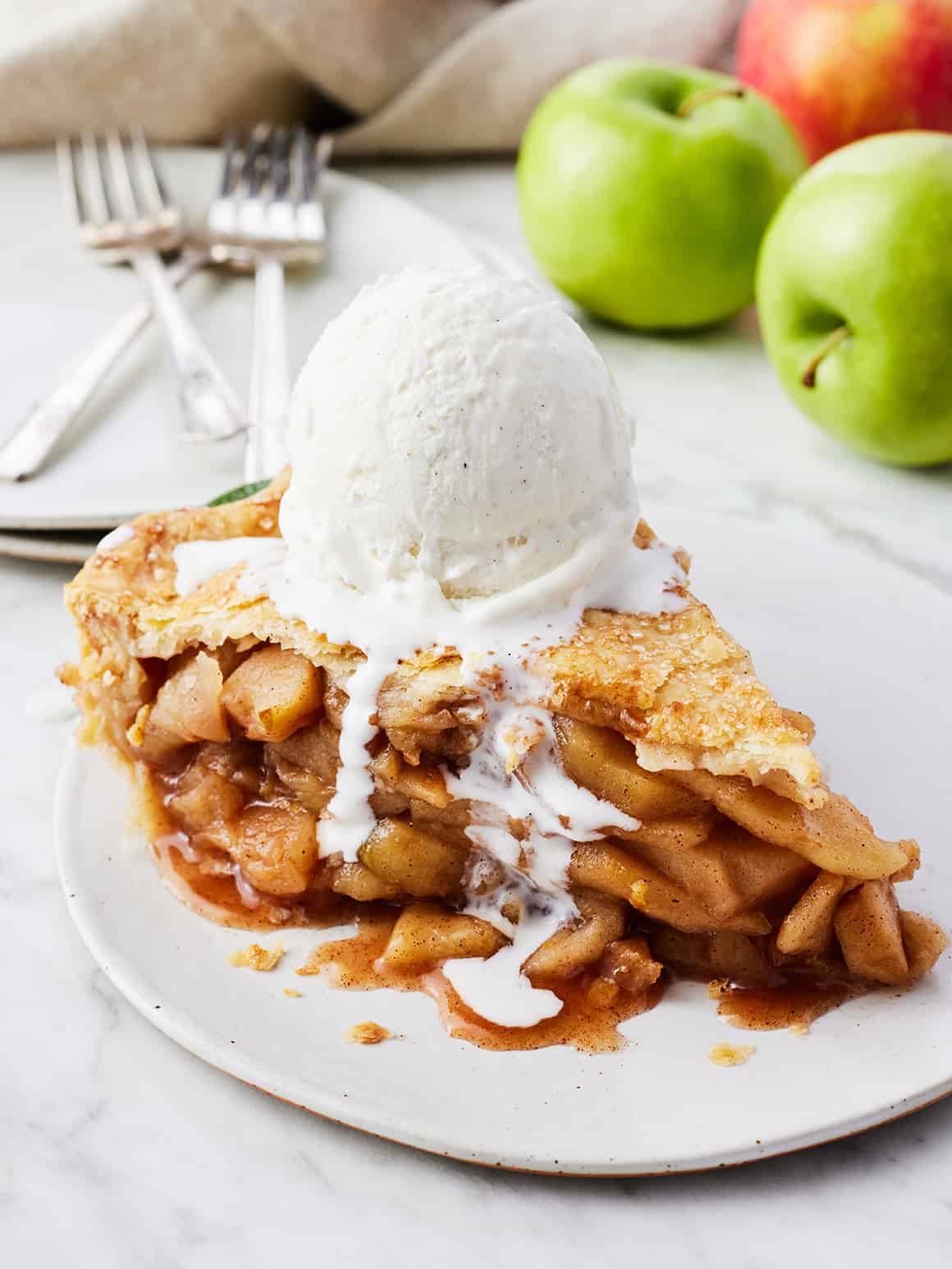 Slice of apple pie on plate with ice cream