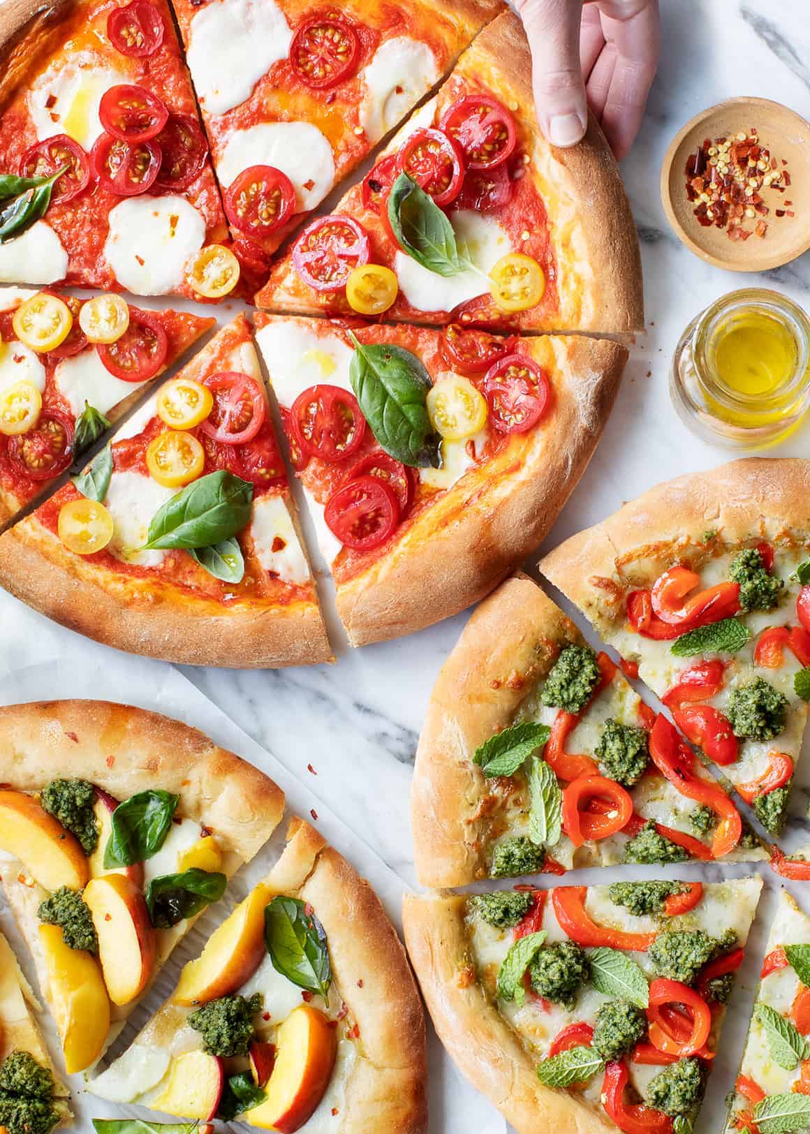 pizza topping ideas - 3 pizzas with tomatoes, cheese, basil, and pesto