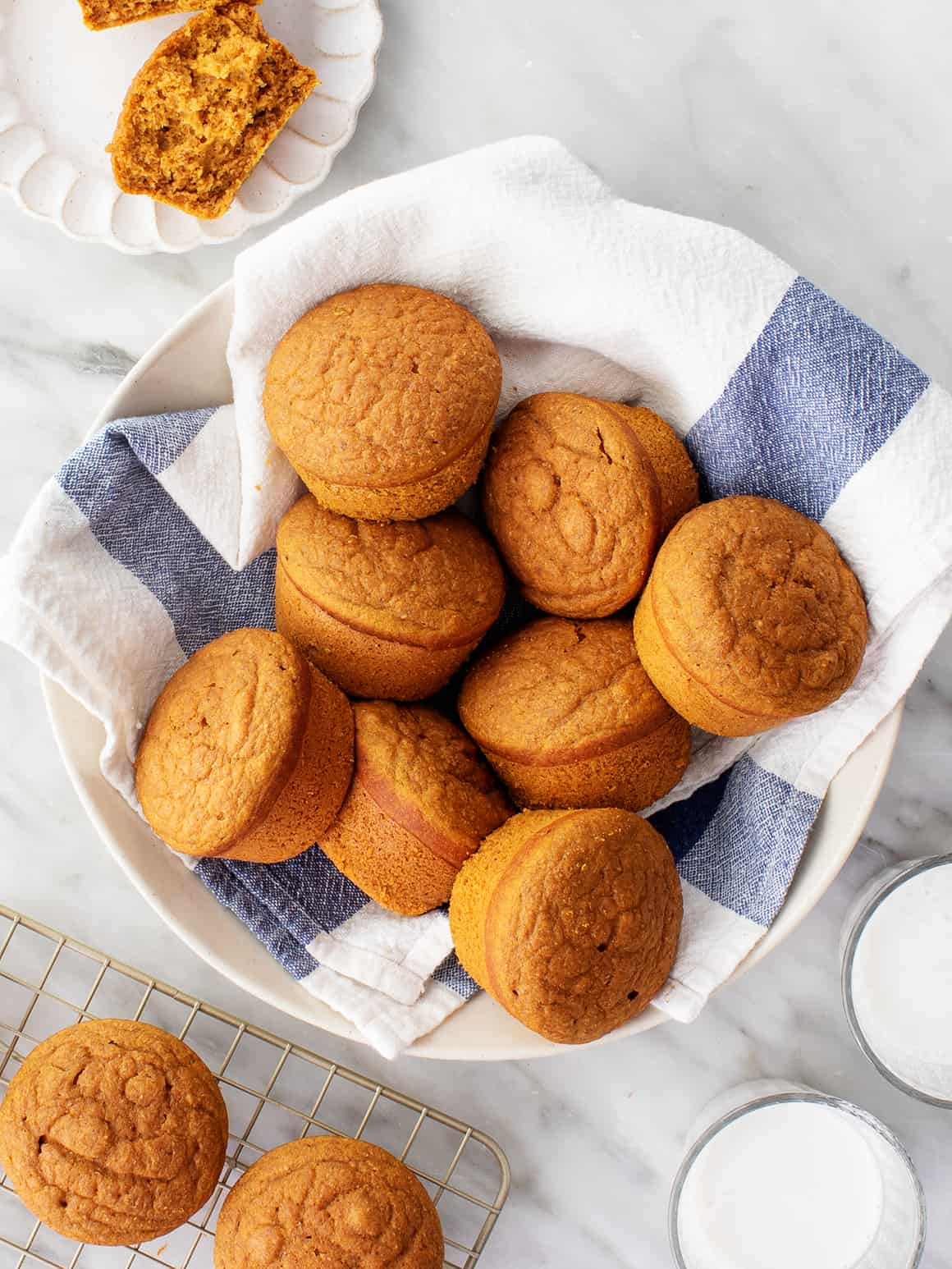 Pumpkin muffins in bowl lined with blue and white kitchen towel